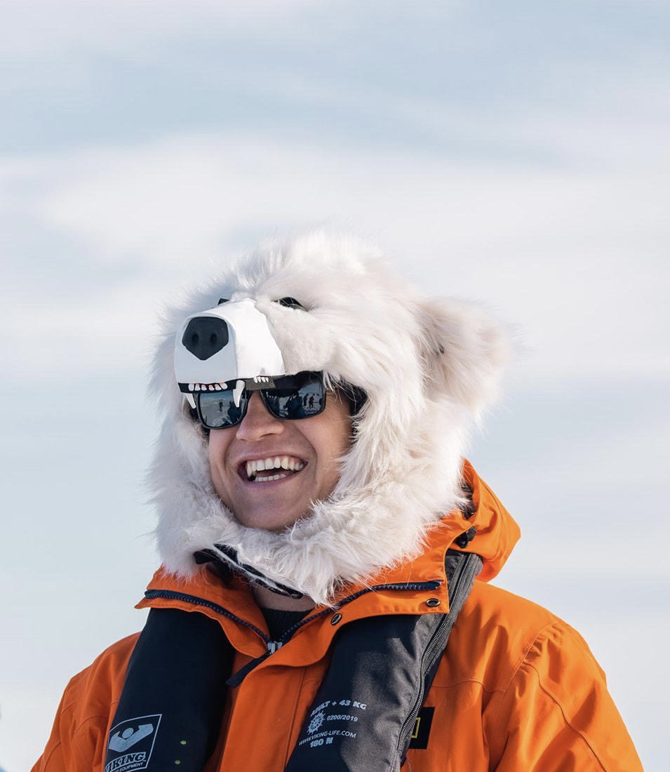 Armin, wearing an expedition hood, smiling